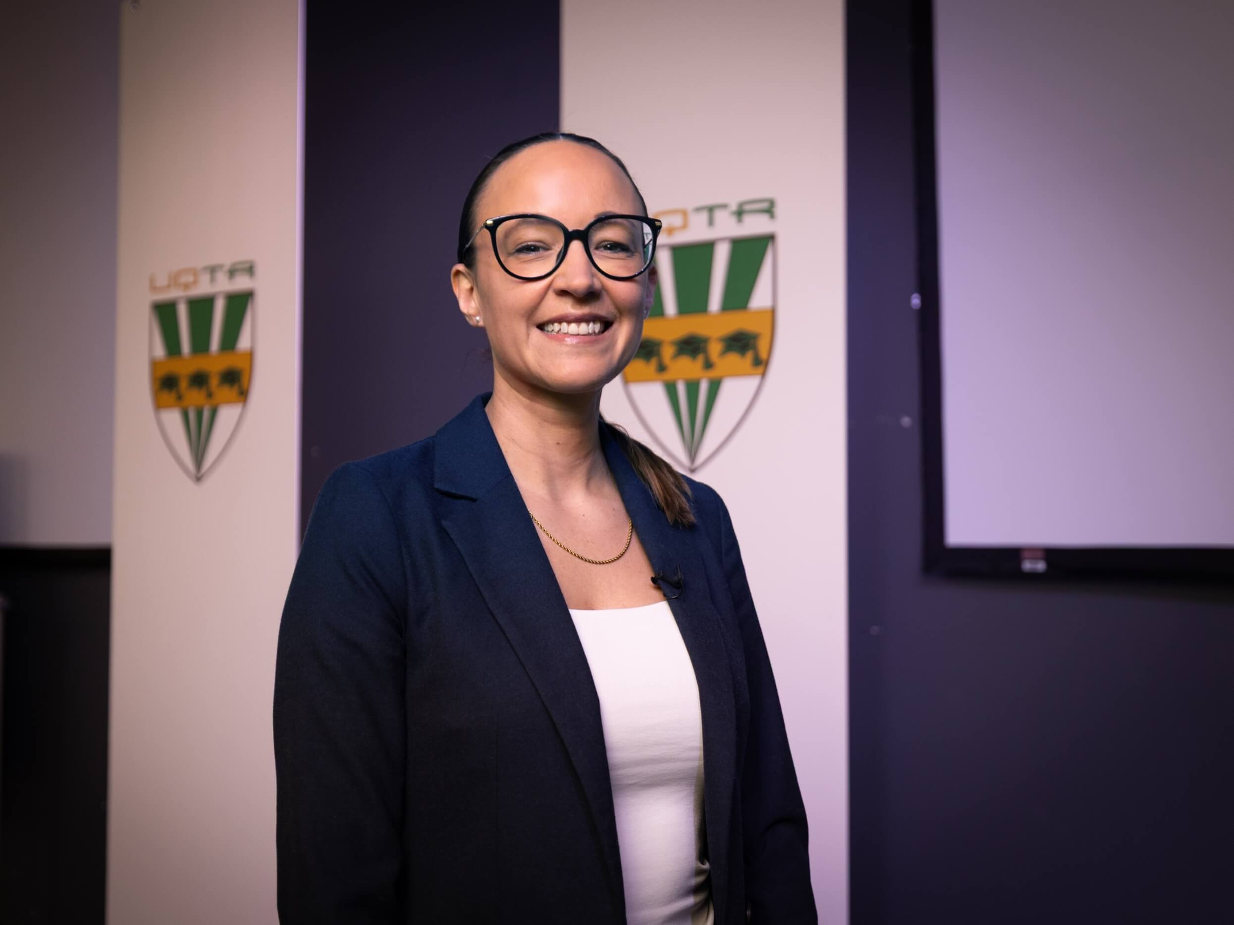 Andrée-Ann Deschênes est professeure au Département de management de l’École de gestion de l’Université du Québec à Trois-Rivières (UQTR). Elle pose ici à l'avant d'un amphithéâtre de l'Université.