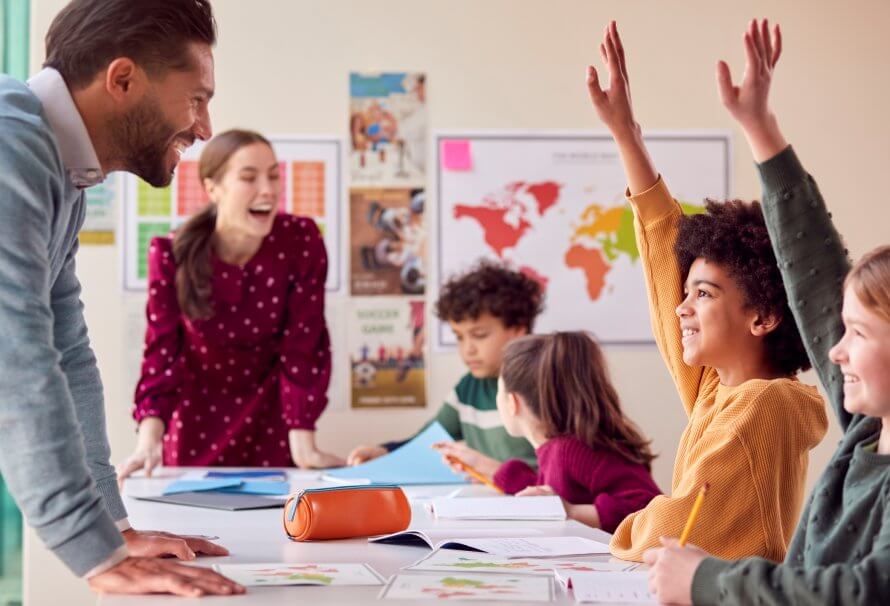 La reconnaissance de la professionnalité des enseignants associés et des superviseurs à l’UQTR Groupe d’élèves multiculturels avec des enseignants en classe qui lèvent la main pour répondre à la question.